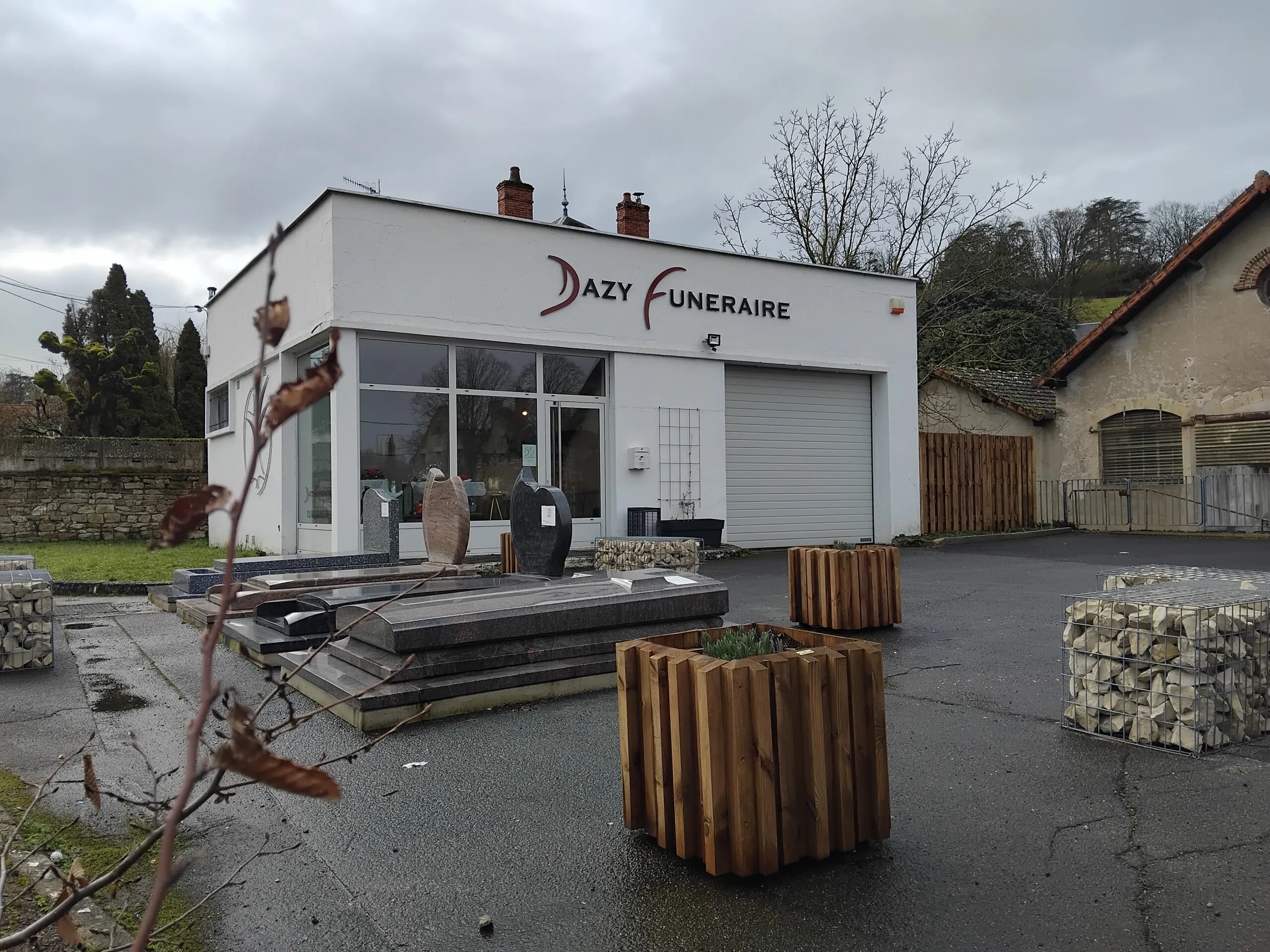 Bâtiment moderne de l'entreprise Dazy Funéraire avec exposition extérieure de monuments