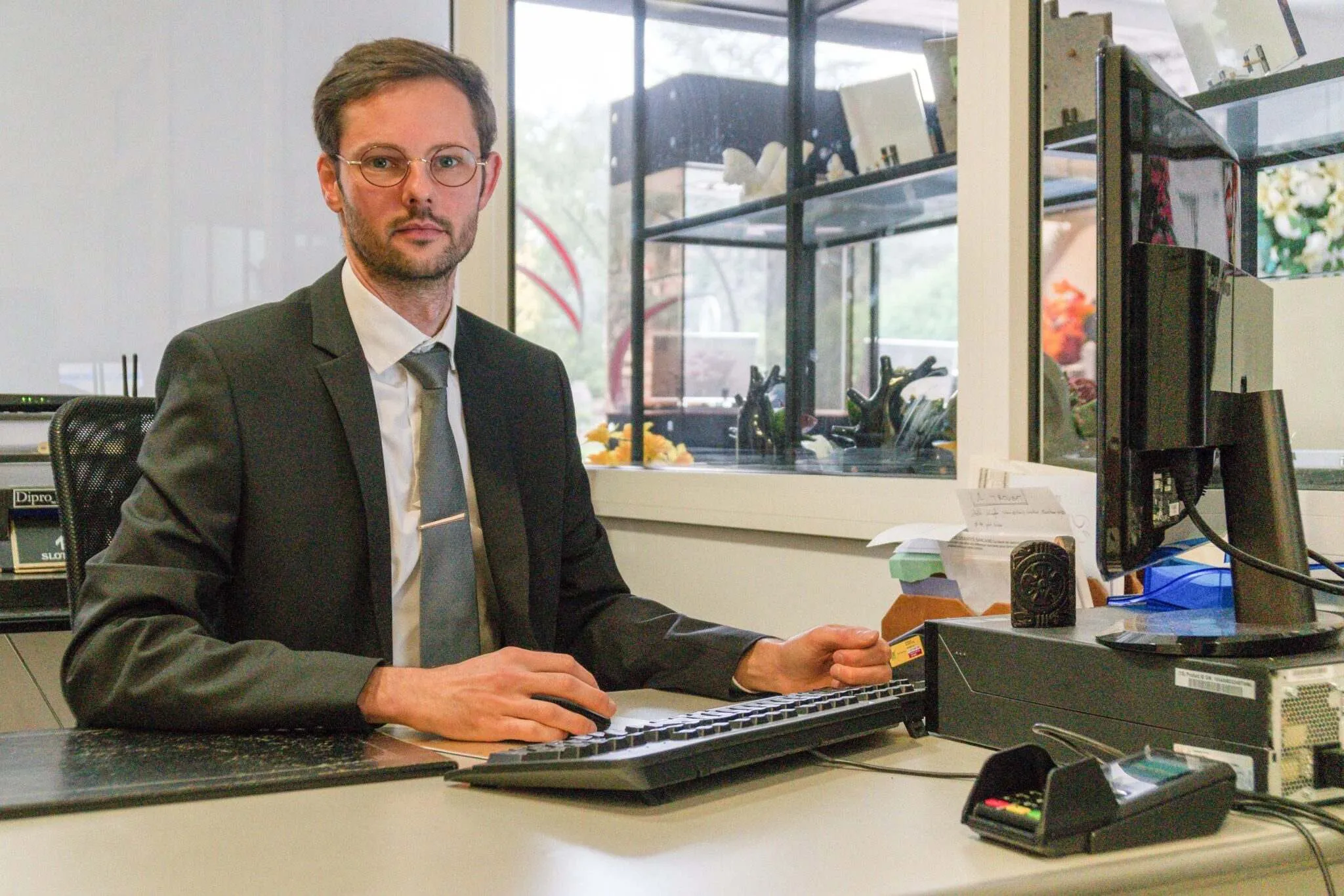 Conseiller funéraire assis à son bureau dans une agence de pompes funèbres